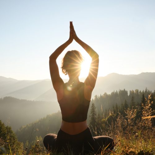 Photo of woman doing yoga pose in the mountains