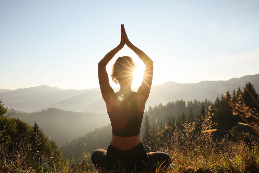 Woman doing yoga pose in the mountains